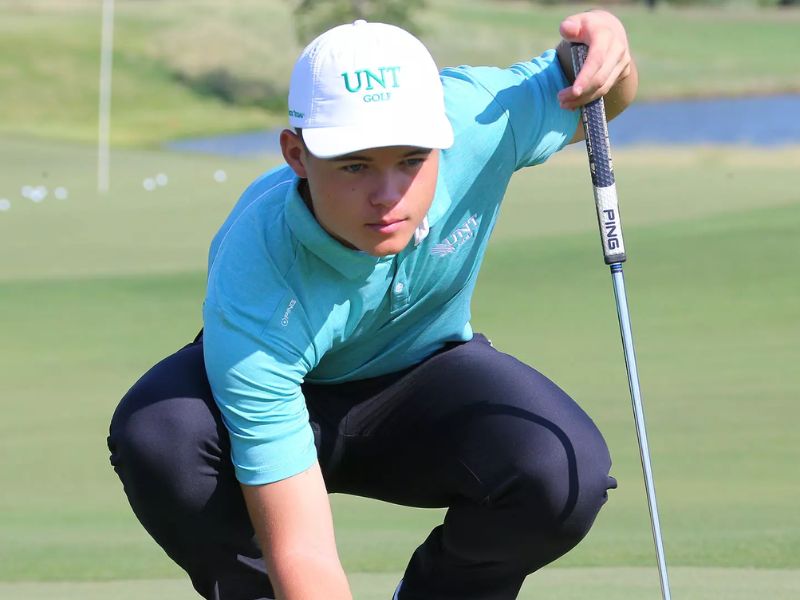 Kristof Ulenaers putting on the green wearing a University of North Texas golf cap
